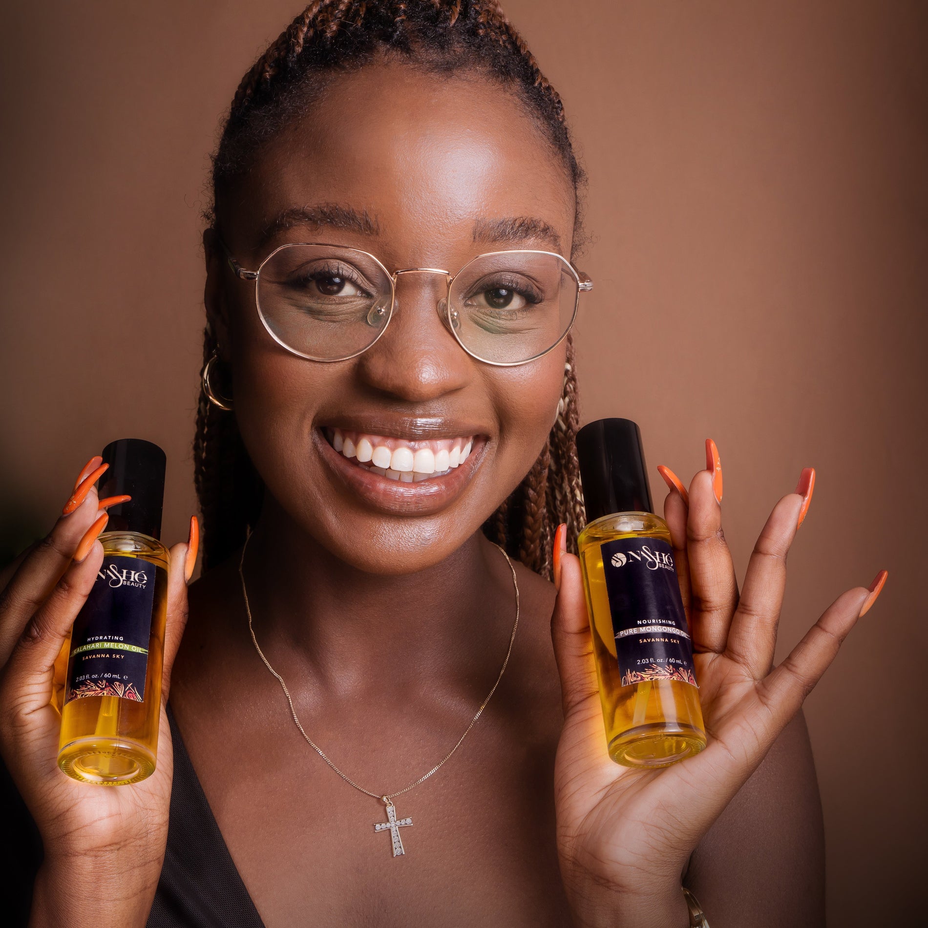 Woman with radiant natural skin holding Nashe Beauty botanical skincare oils representing African-inspired holistic beauty rituals